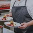 Koch trägt zwei Teller mit kunstvoll angerichteten Desserts