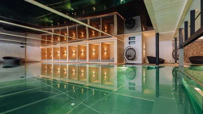 Moderner Indoor-Pool mit Lounge-Bereichen und Hängekorb-Stühlen