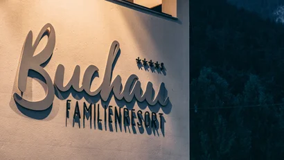 Beschilderung des Buchau Familienresorts an einer beleuchteten Wand bei Dämmerung