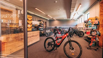 Sportshop mit Fahrrädern, Helmen und Zubehör in einem hellen Geschäft
