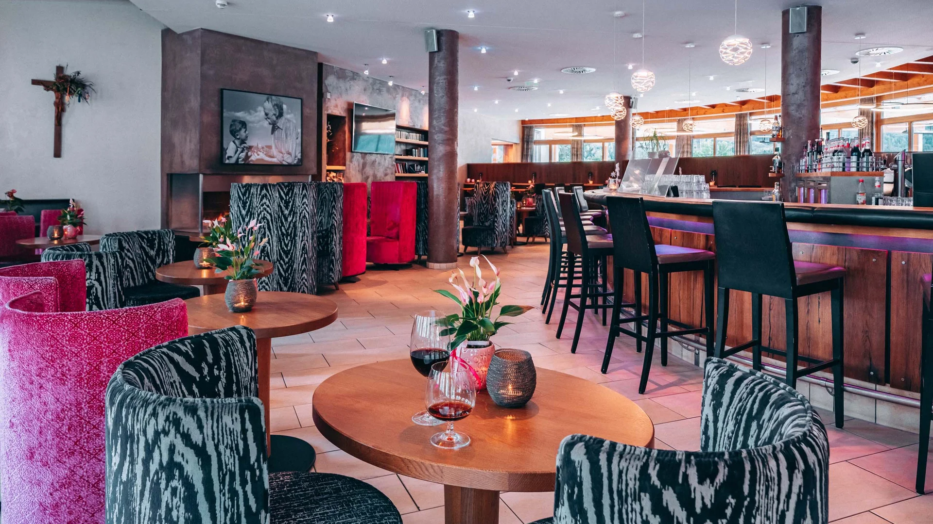 Gemütliche Bar mit bunten Sesseln und Holztheke in modernem Interieur